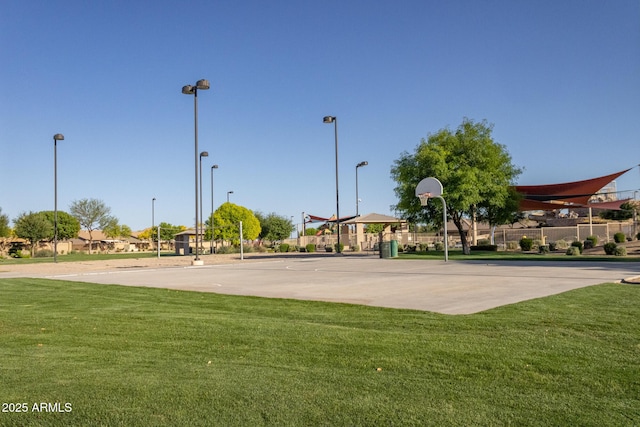 view of basketball court with community basketball court, a lawn, and fence