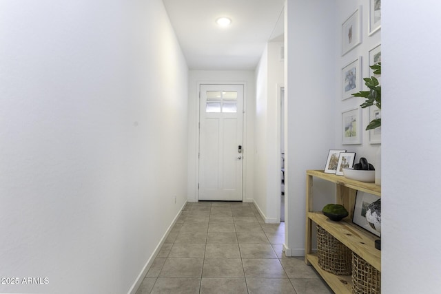 doorway featuring baseboards and light tile patterned flooring