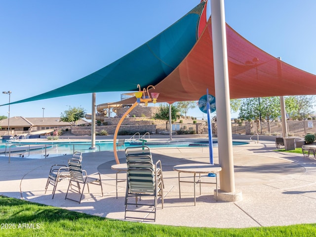 pool with a patio area and fence