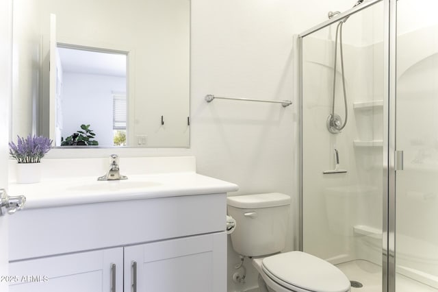 bathroom featuring a stall shower, vanity, and toilet