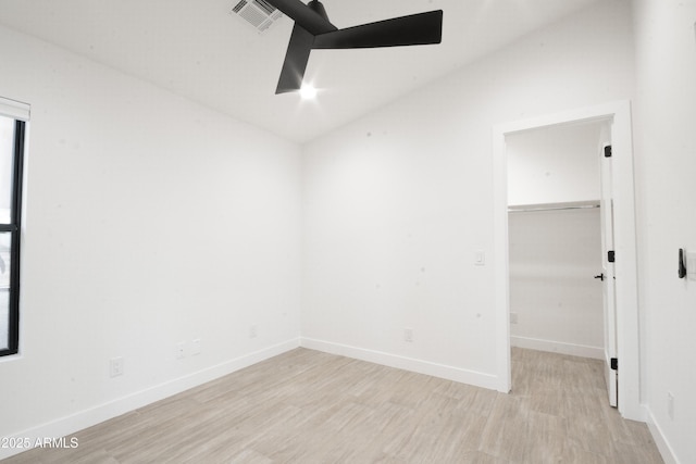 spare room featuring light wood-type flooring and lofted ceiling