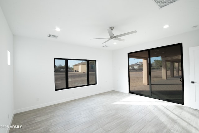 spare room with a wealth of natural light, light hardwood / wood-style flooring, and ceiling fan