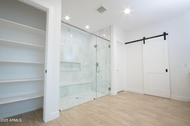 bathroom featuring wood-type flooring and a shower with shower door