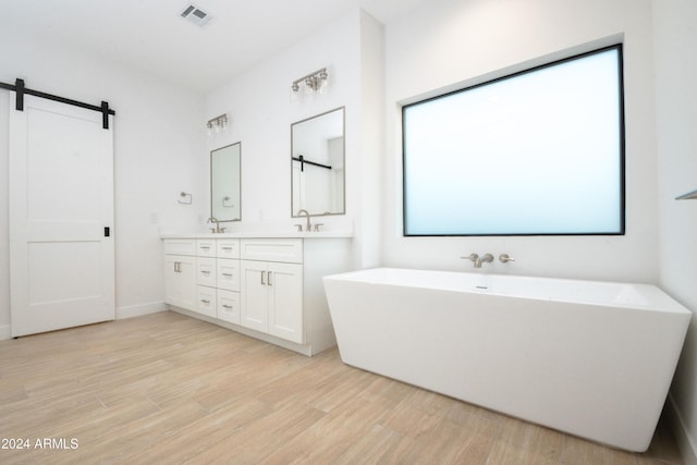 bathroom featuring a washtub, vanity, and wood-type flooring