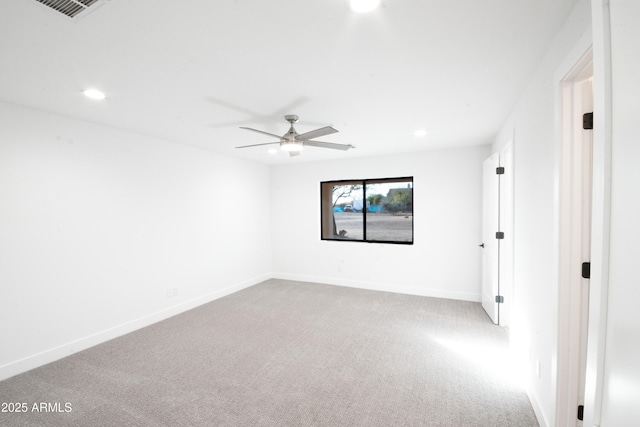 spare room with ceiling fan and light carpet