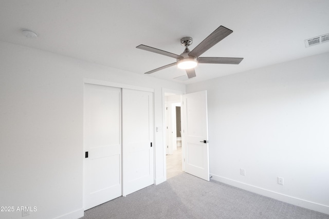 unfurnished bedroom with carpet flooring, ceiling fan, and a closet