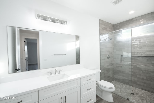 bathroom with vanity, toilet, and a shower with door