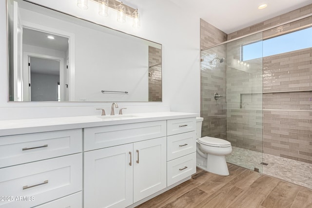 bathroom with hardwood / wood-style flooring, vanity, toilet, and an enclosed shower