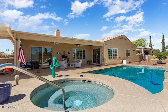 rear view of house featuring a pool with hot tub and a patio area