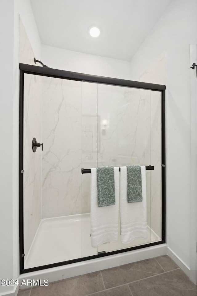 bathroom featuring walk in shower and tile patterned flooring