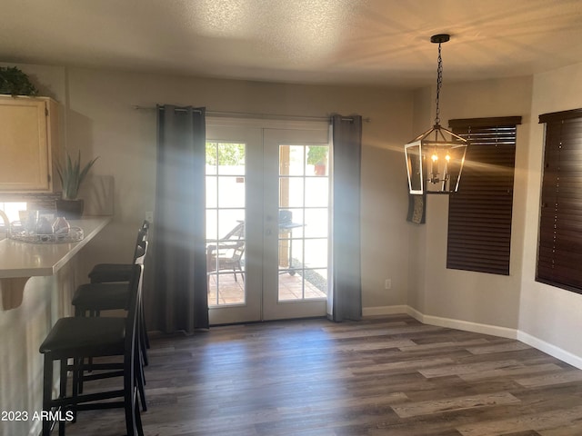 dining space featuring french doors, a textured ceiling, and dark hardwood / wood-style flooring