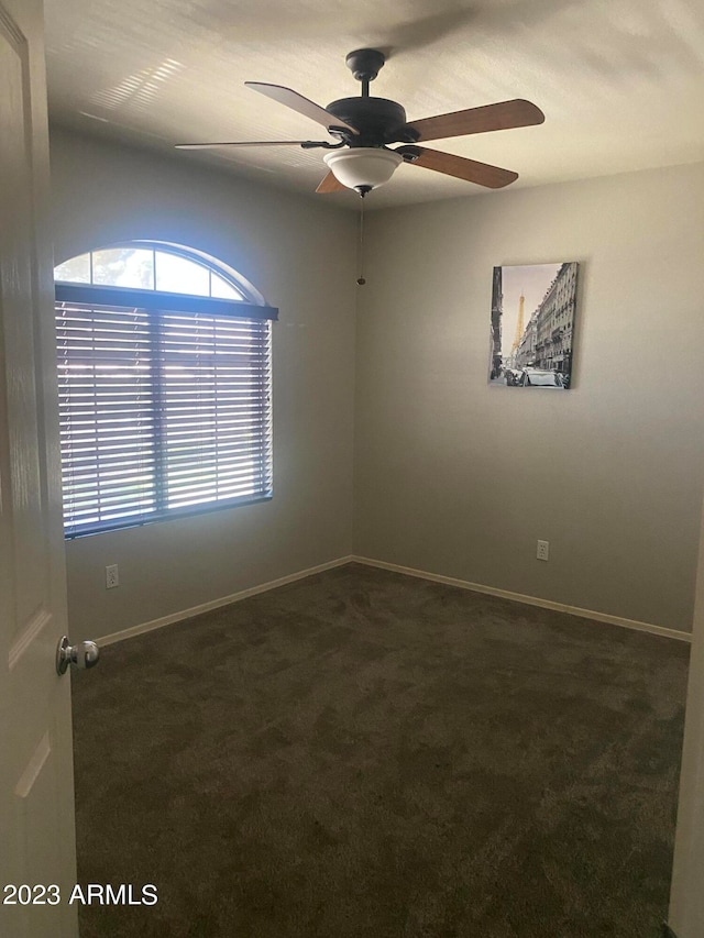 carpeted spare room featuring ceiling fan