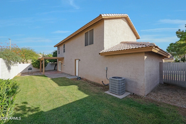 back of property featuring a patio, a lawn, and central AC unit