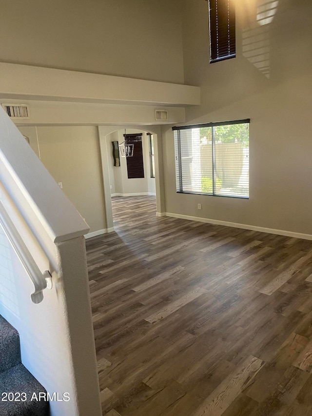 interior space featuring a high ceiling and dark hardwood / wood-style floors