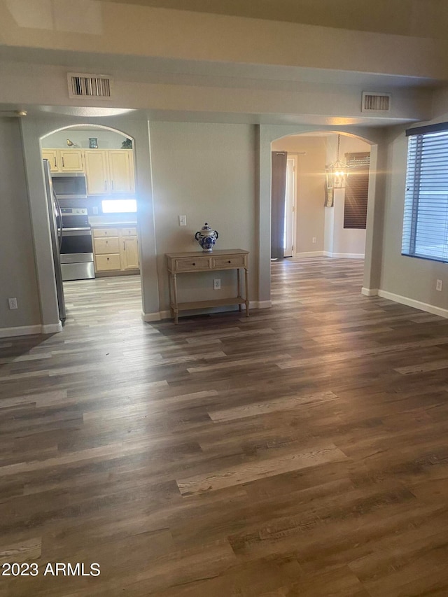 hallway with a notable chandelier and dark wood-type flooring