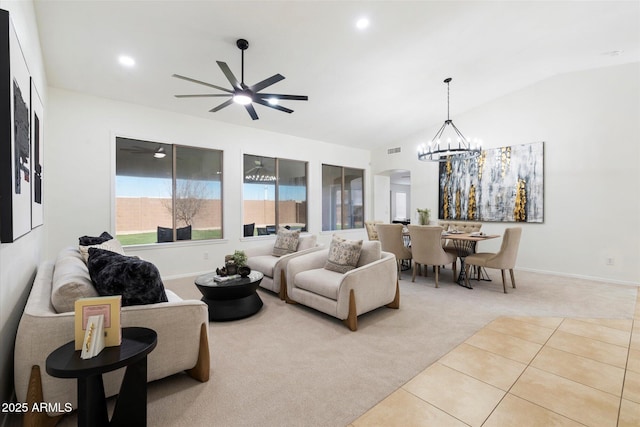 carpeted living room with lofted ceiling and ceiling fan with notable chandelier