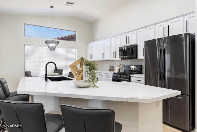 kitchen featuring an island with sink, stainless steel appliances, sink, and hanging light fixtures