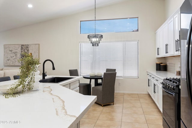 kitchen featuring sink, backsplash, hanging light fixtures, light stone counters, and black range with gas cooktop