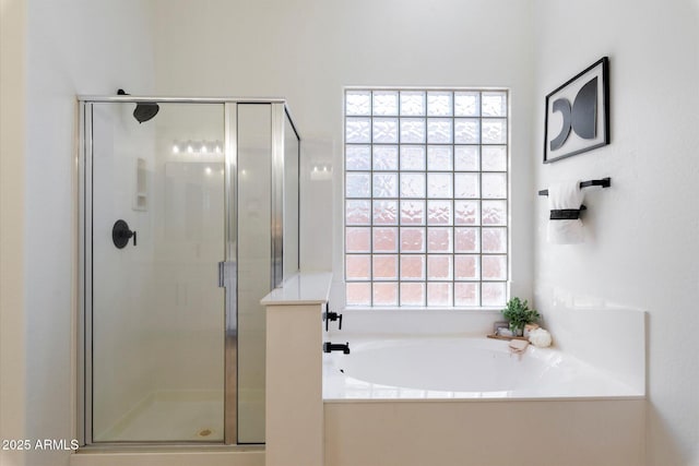 bathroom featuring a wealth of natural light and plus walk in shower