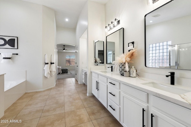 bathroom with vanity, a wealth of natural light, tile patterned floors, and a bathtub