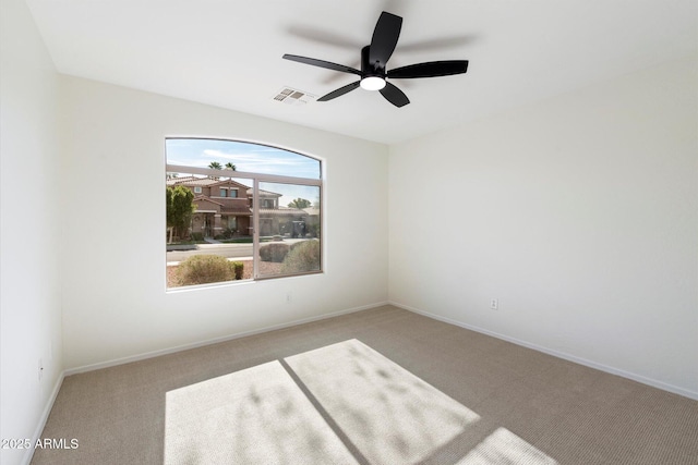 empty room with ceiling fan and light carpet