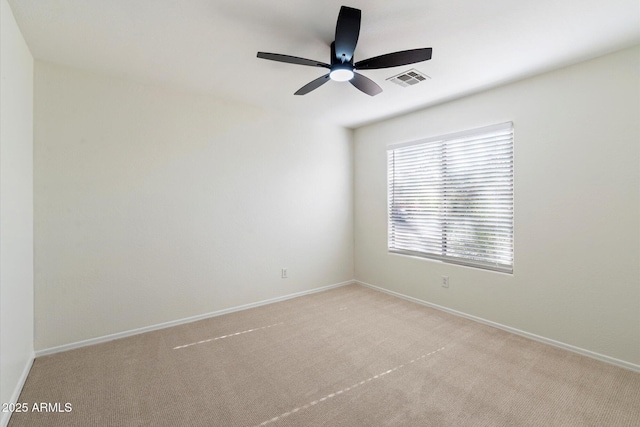 spare room featuring ceiling fan and light colored carpet