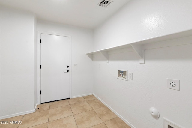 clothes washing area with gas dryer hookup, hookup for a washing machine, hookup for an electric dryer, and light tile patterned flooring