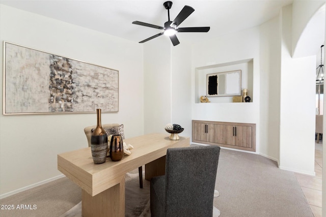 carpeted office space featuring ceiling fan