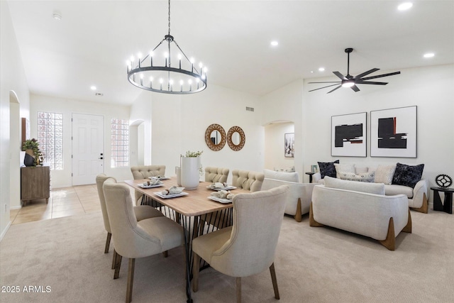 carpeted dining space with ceiling fan and vaulted ceiling