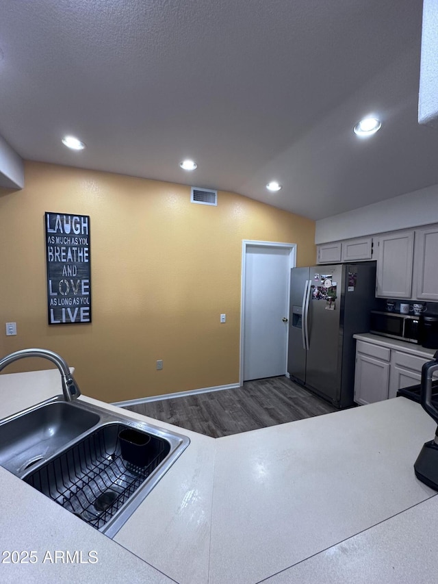 kitchen with lofted ceiling, sink, dark wood-type flooring, and appliances with stainless steel finishes