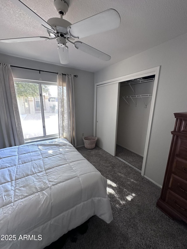 bedroom featuring dark colored carpet, ceiling fan, a textured ceiling, and a closet