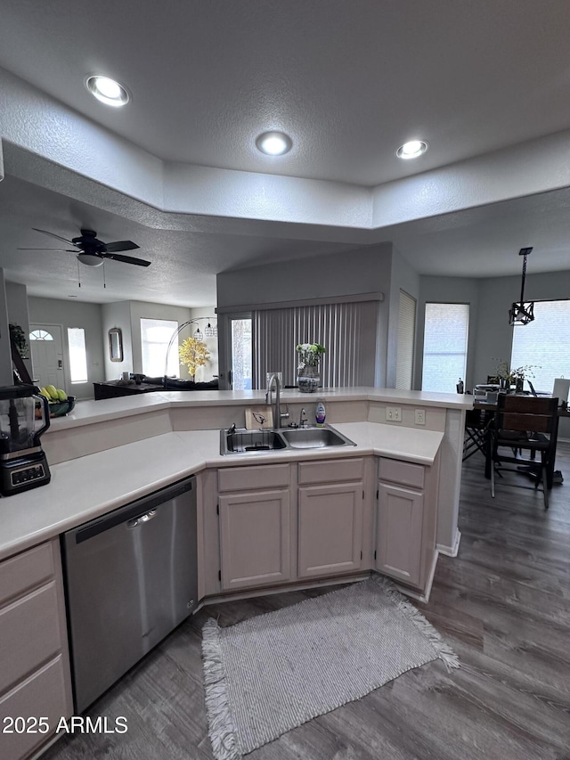 kitchen featuring sink, dark hardwood / wood-style flooring, stainless steel dishwasher, kitchen peninsula, and a healthy amount of sunlight