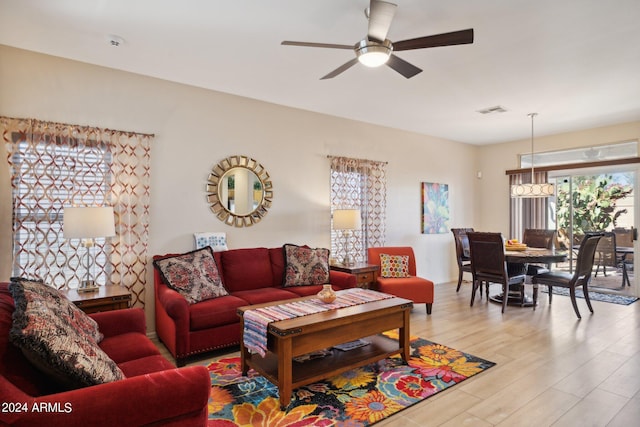 living room with light hardwood / wood-style flooring and ceiling fan