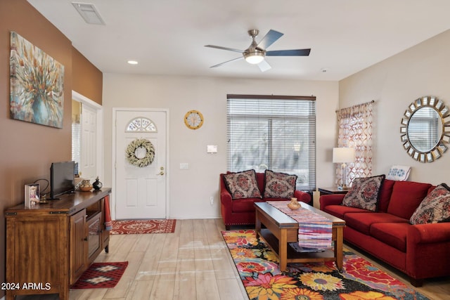 living room with light hardwood / wood-style flooring and ceiling fan