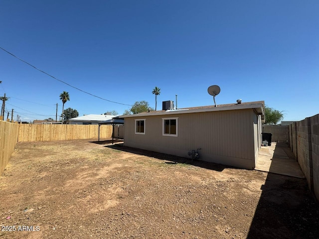 rear view of property with a fenced backyard and central air condition unit