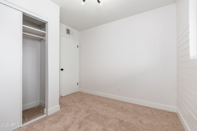 unfurnished bedroom with carpet, a closet, baseboards, and visible vents