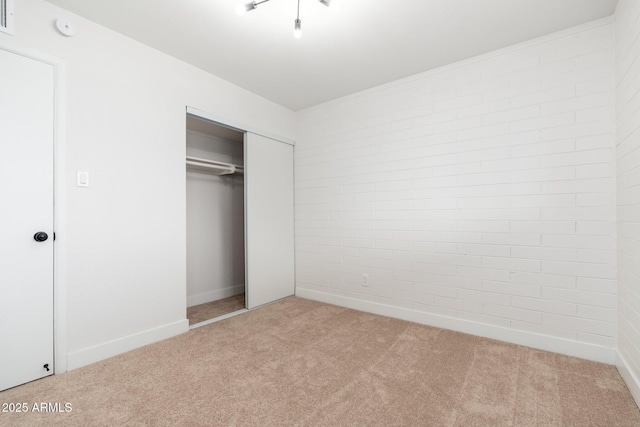 unfurnished bedroom with carpet, a closet, baseboards, and visible vents