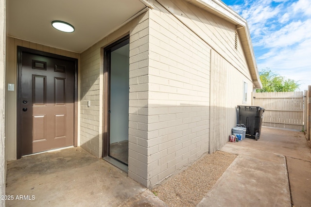 entrance to property featuring a patio and fence