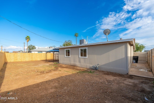 back of property with central AC unit and a fenced backyard