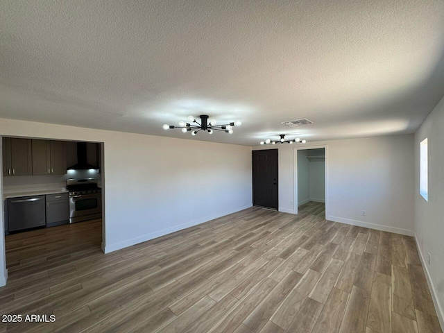 interior space with visible vents, a textured ceiling, and wood finished floors