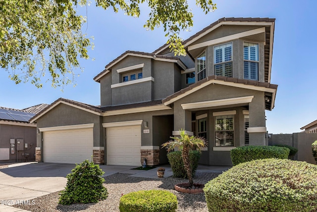 view of front of home featuring a tile roof, concrete driveway, stone siding, and stucco siding