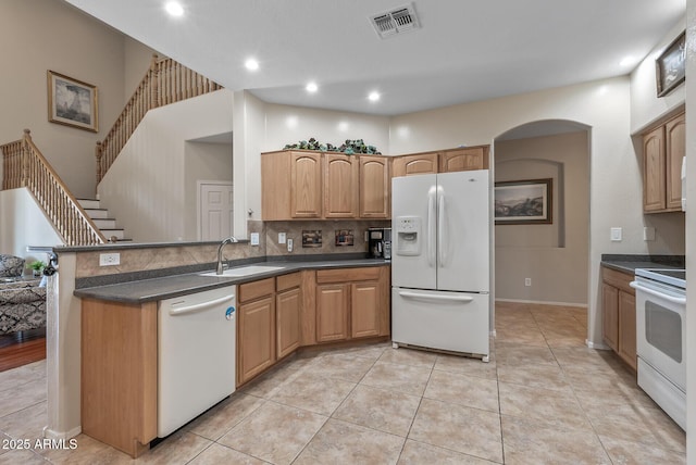 kitchen featuring dark countertops, visible vents, white appliances, and a sink