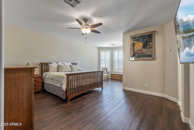 bedroom featuring a ceiling fan, visible vents, dark wood-style flooring, and baseboards