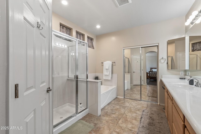 bathroom featuring vanity, visible vents, a shower stall, a garden tub, and tile patterned floors