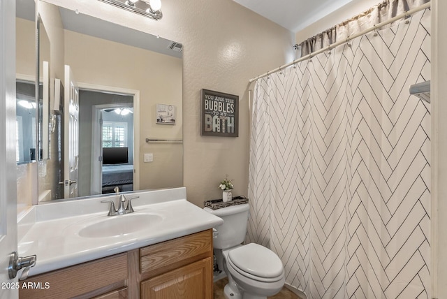 ensuite bathroom featuring vanity, a shower with shower curtain, visible vents, toilet, and connected bathroom