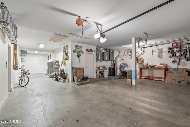 garage featuring water heater, a workshop area, and a garage door opener