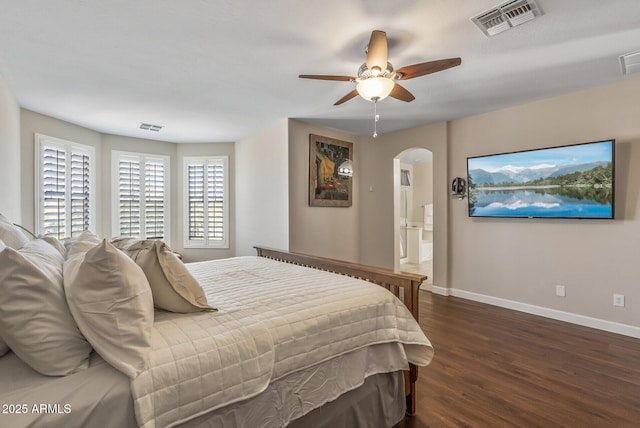 bedroom featuring visible vents, arched walkways, baseboards, and wood finished floors