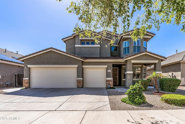 view of front of home featuring stone siding, stucco siding, a tiled roof, and concrete driveway