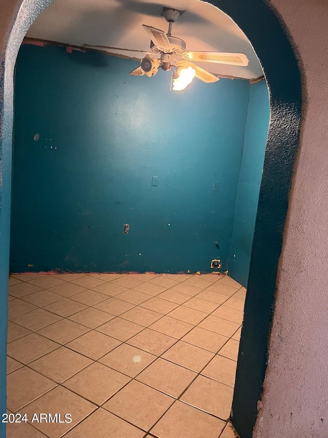 spare room with ceiling fan and tile floors