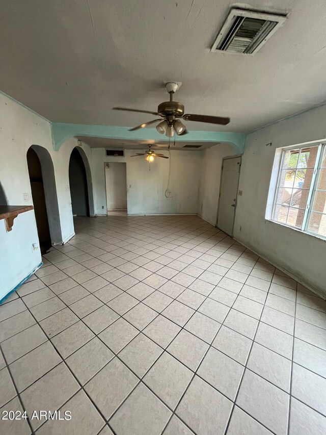 empty room with light tile flooring and ceiling fan